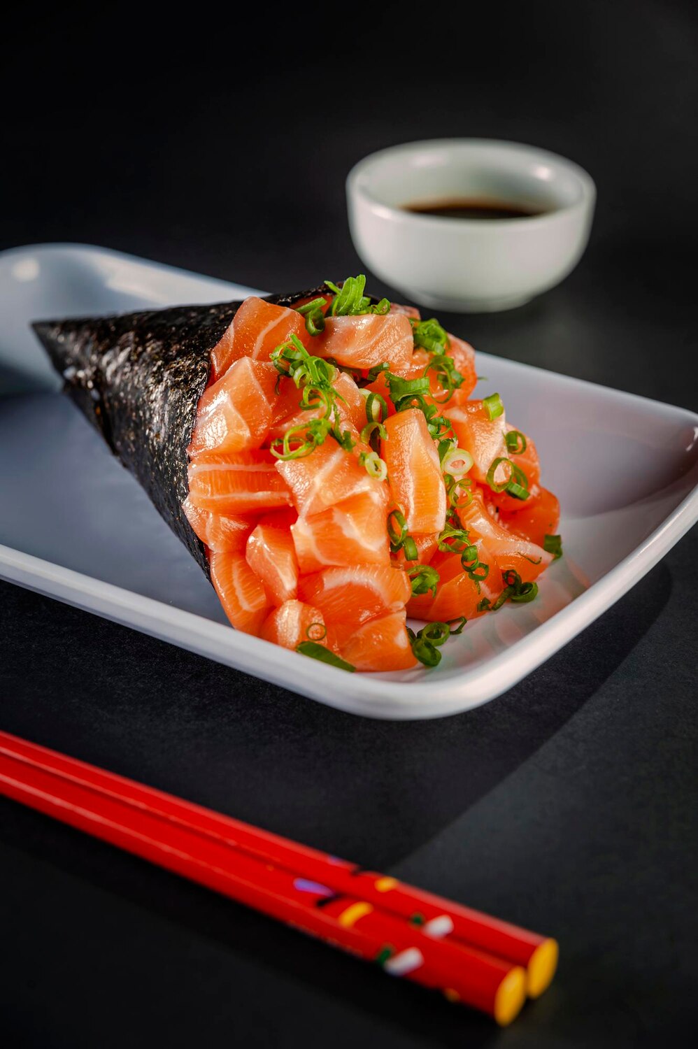 Salmon temaki white plate black background with soy sauce chopsticks closeup 311876 746 Salmon temaki white plate black background with soy sauce chopsticks closeup 311876 746