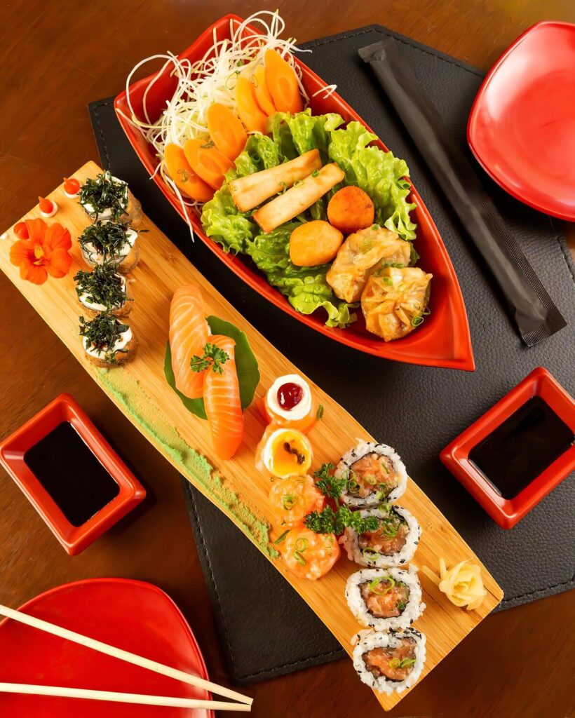 Boat with red bow is table with plate sushi other food 919857 578
